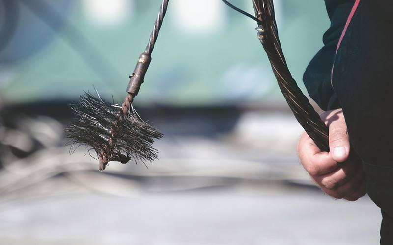 Professional chimney sweep technician cleaning a chimney flue in Atlanta